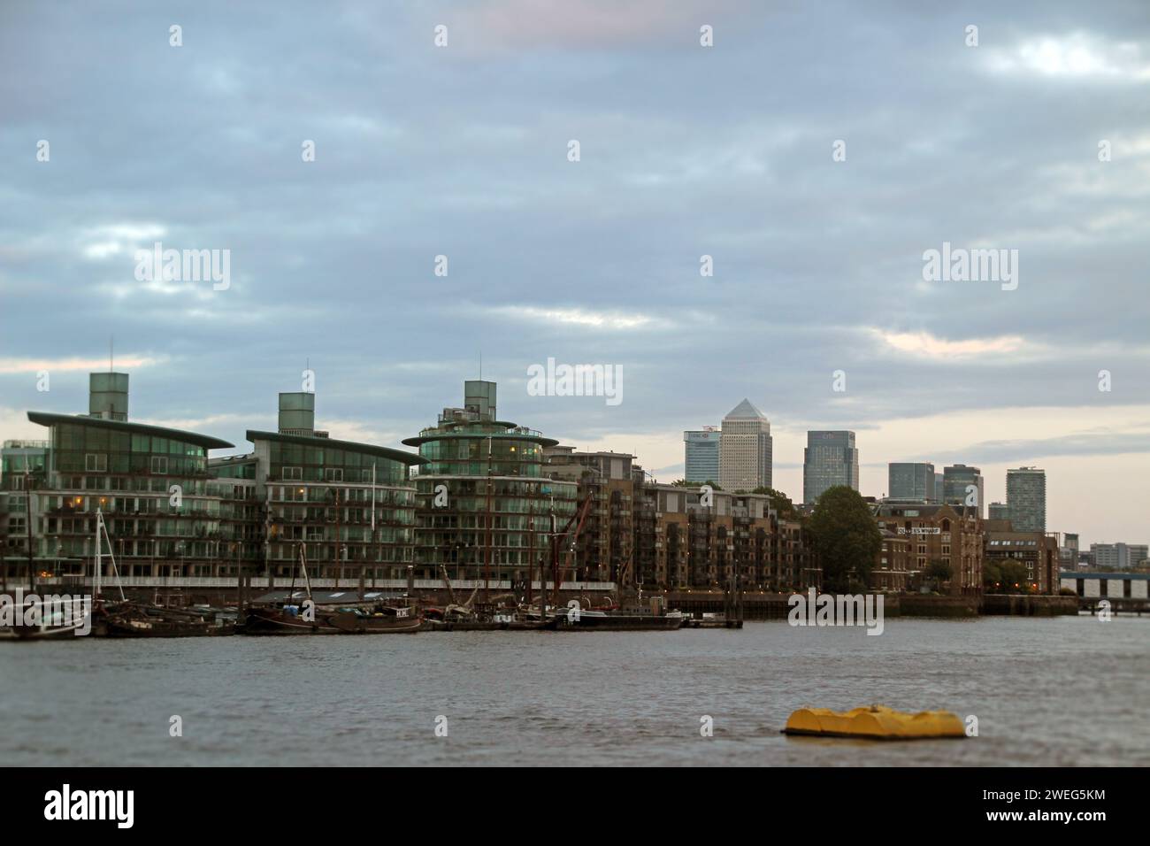 Aerial shot of the River Thames in London, UK, featuring a stormy sky and boats and buildings along the banks Stock Photo