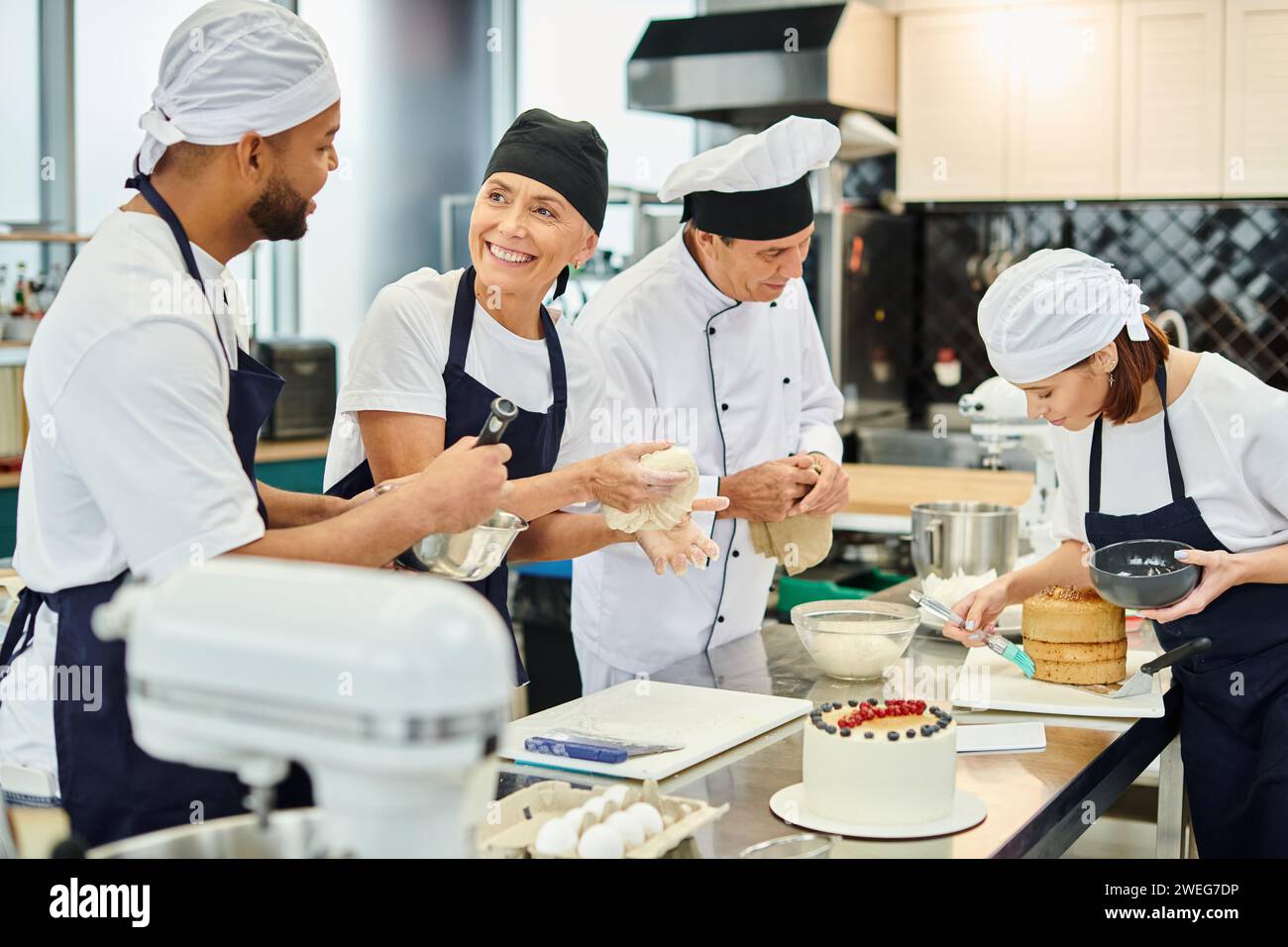 jolly chef smiling at her african american colleague with their friend ...