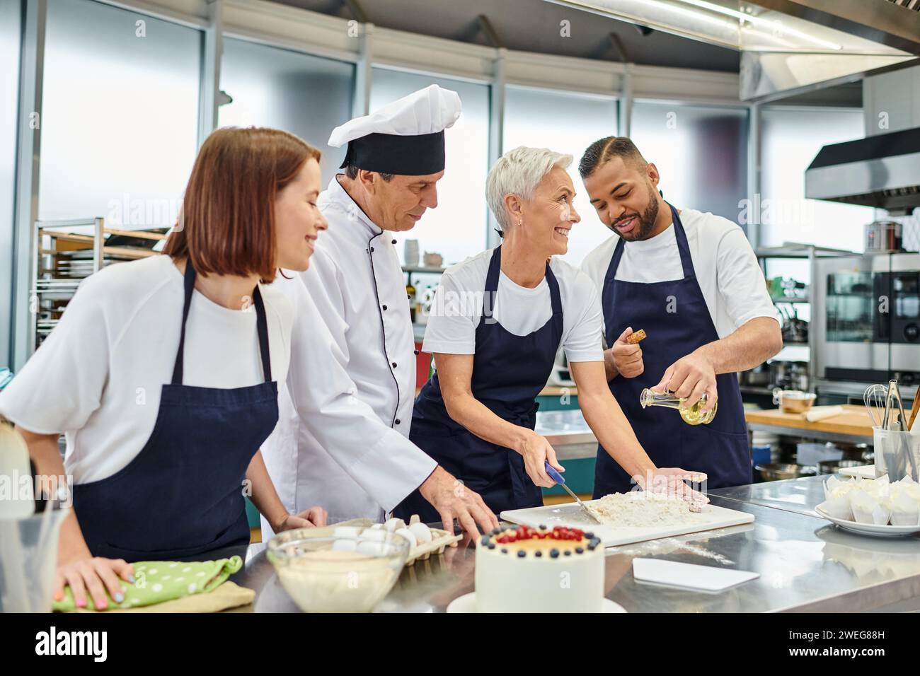 joyous good looking diverse chefs having fun while baking delicious cakes on kitchen, confectionery Stock Photo