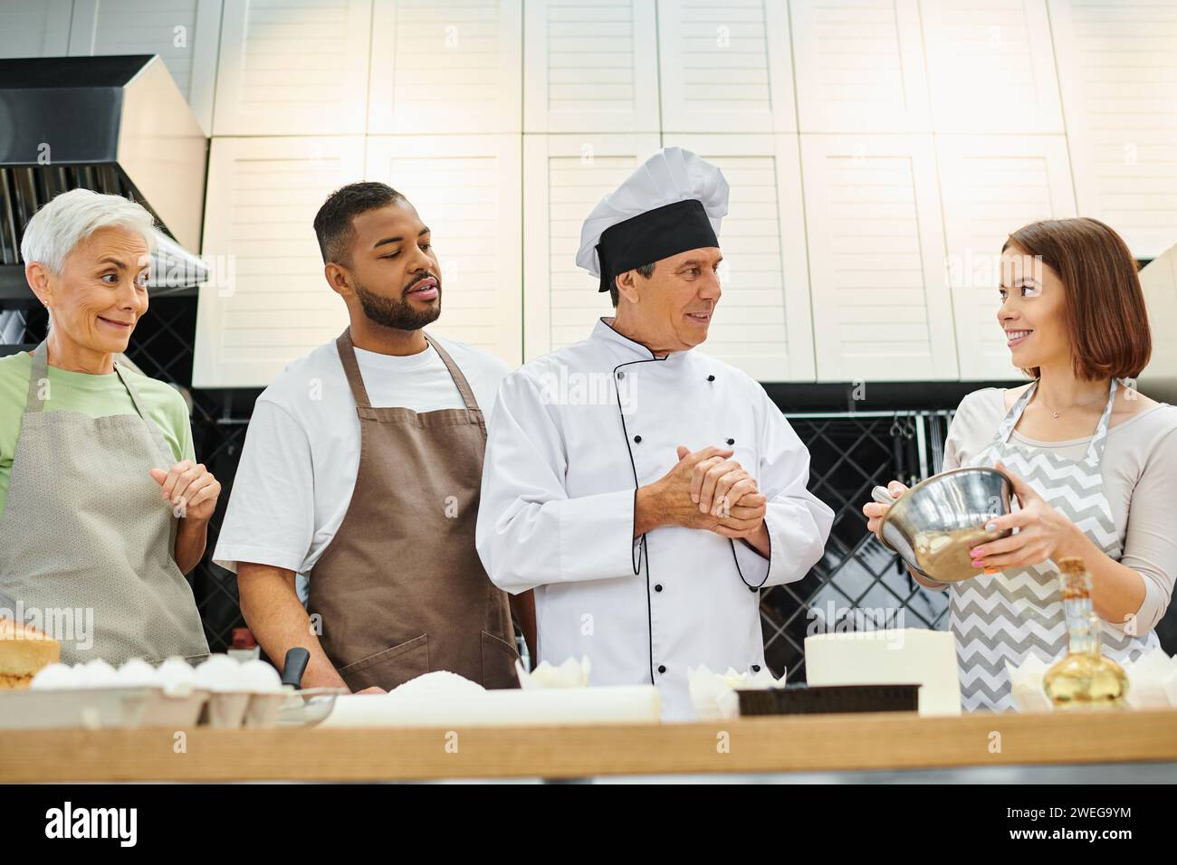 young beautiful woman whisking dough and smiling at diverse friends and ...