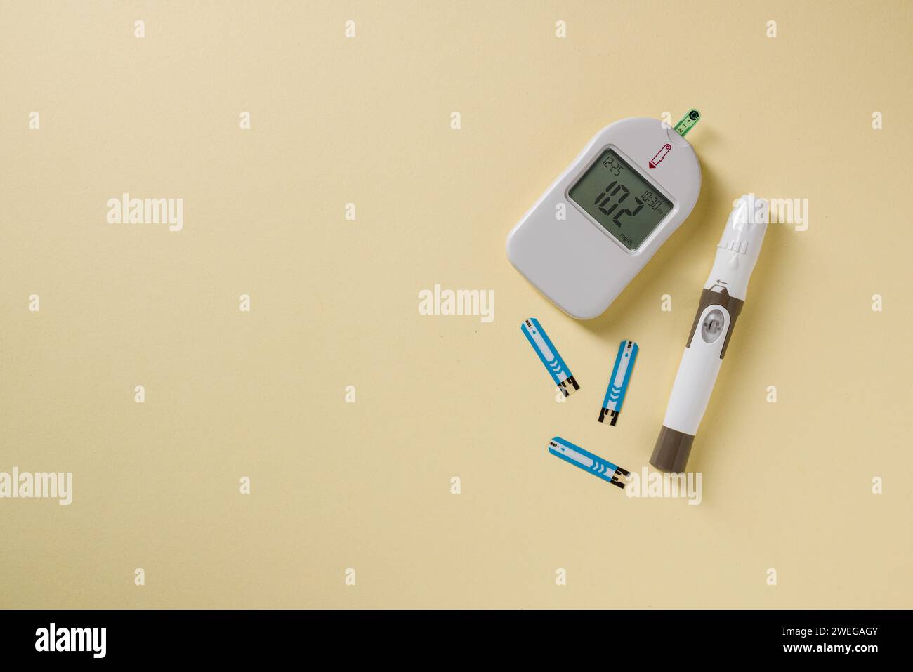 Top view of glucometer, lancet pen and strips on yellow background. diabetes test kit Stock Photo