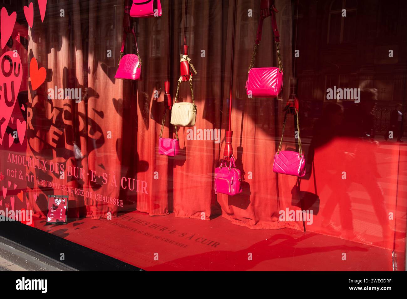 Paris, France - February 21, 2023: Valentine red decoration with hearts as background for fancy handbags displayed in window of BHV department store. Stock Photo