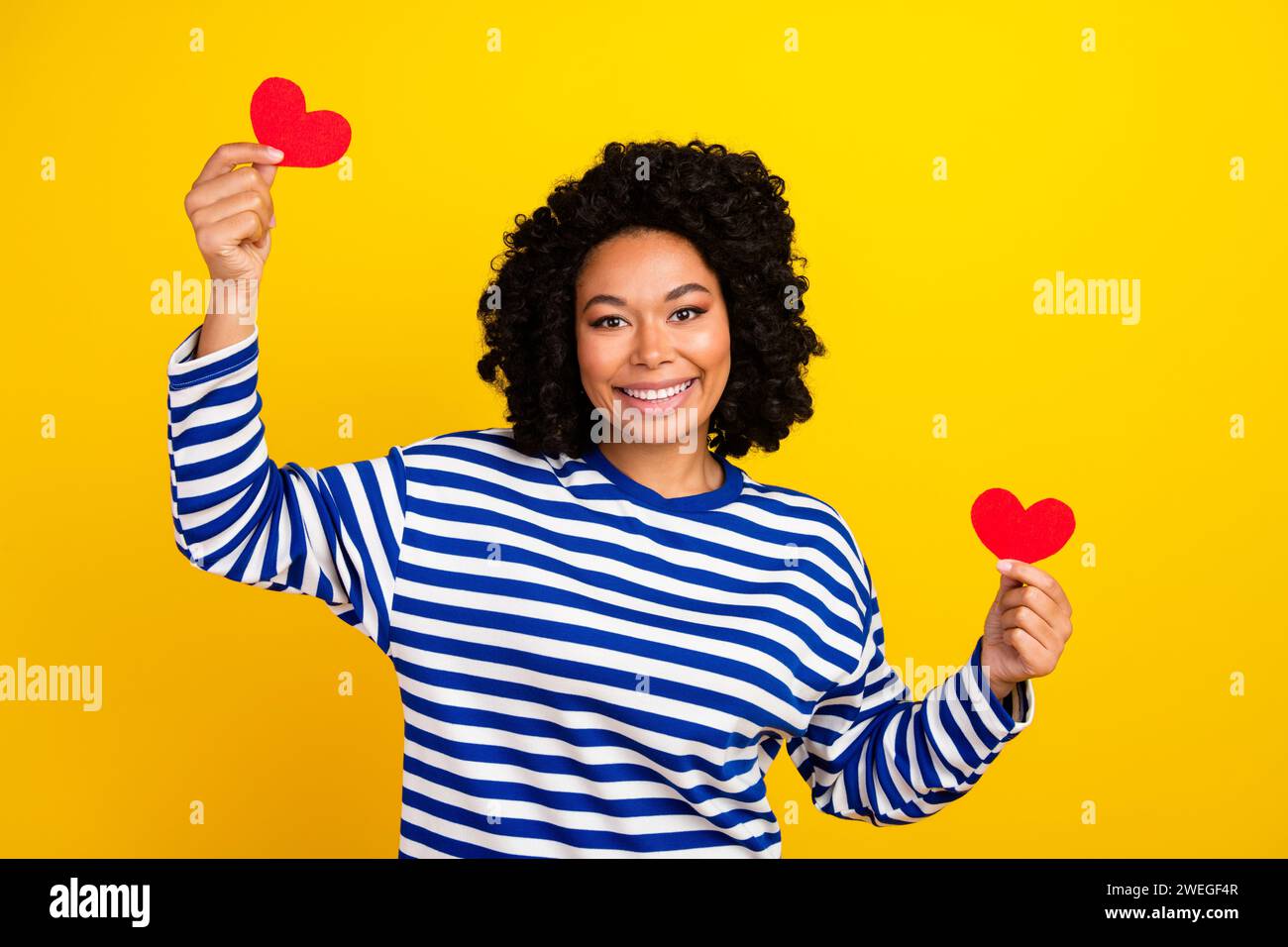 Photo of charming lovely pretty girl wear trendy clothes showing two little red cards isolated on yellow color background Stock Photo