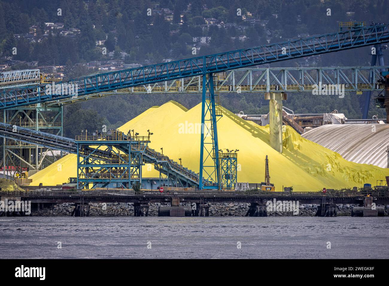 Large piles of yellow sulphur on the waterfront in North vancouver, British Columbia, Canada on 31 May 2023 Stock Photo