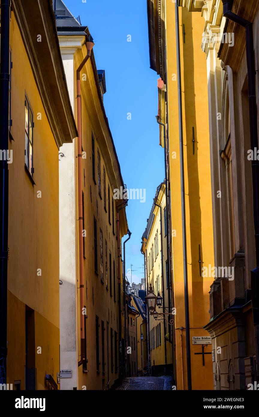 Narrow street with colourful high facades of old houses in the old town Gamla Stan in Stockholm, Sweden Stock Photo