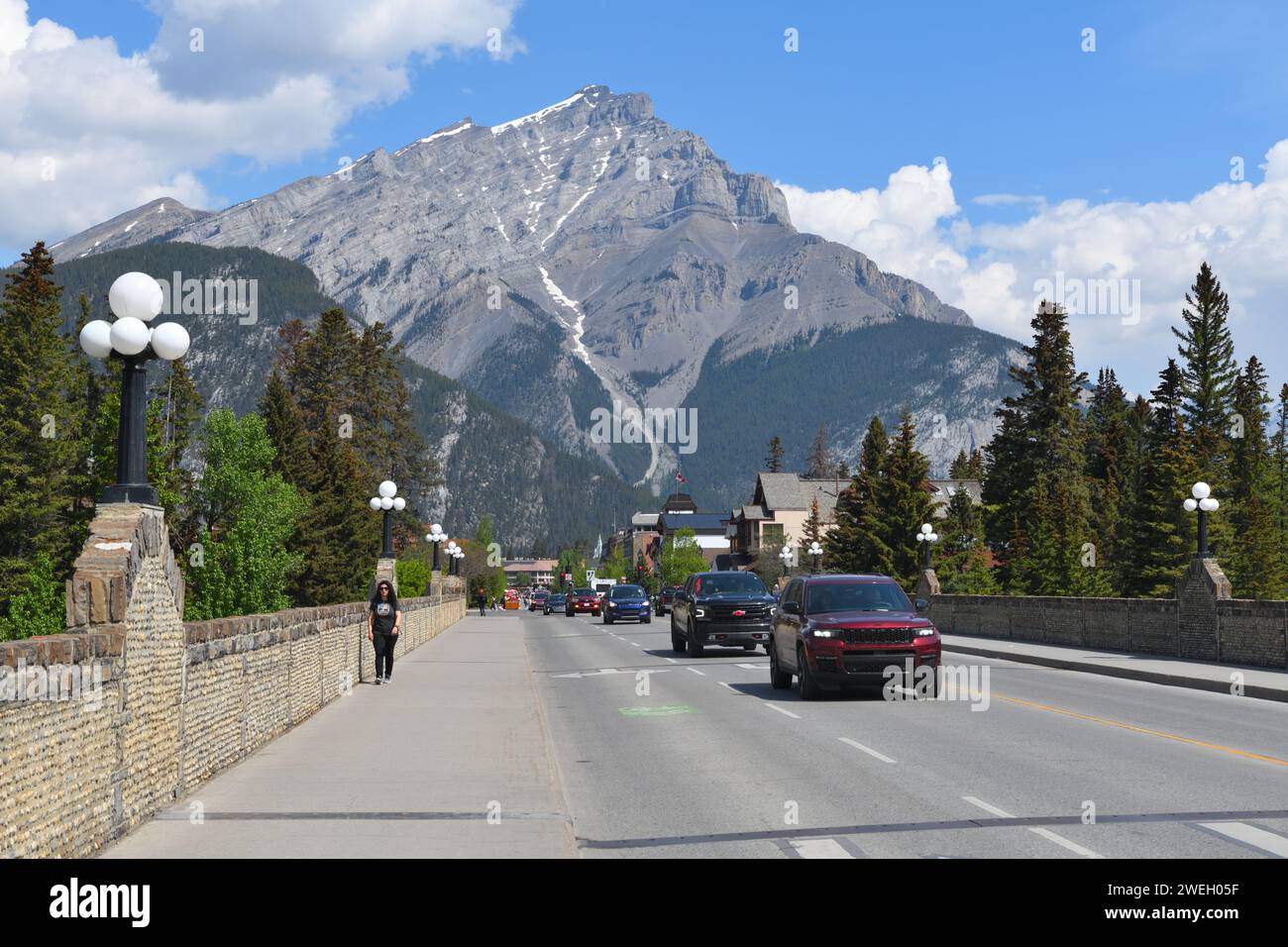 Traffic moving through Banff Avenue with Cascade Mountain in the background. Banff National Park, Alberta, Canada Stock Photo