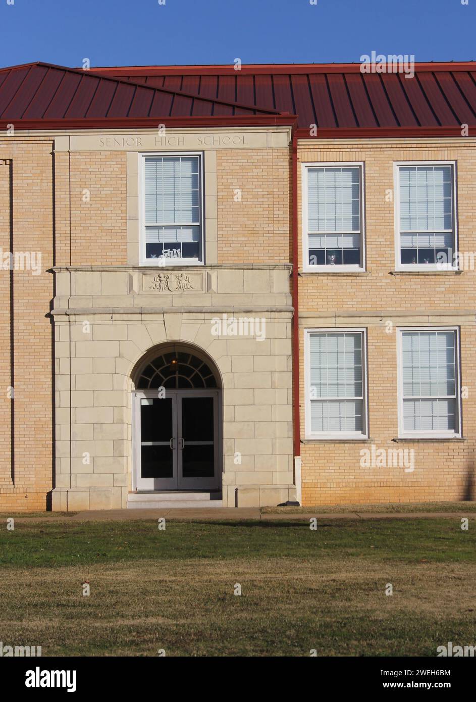 The facade of an Old School Building in New London, TX on a sunny day