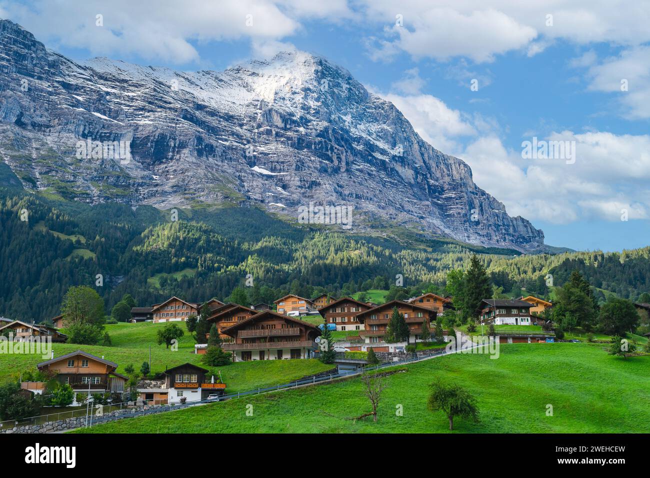 The Bernese Alps tower over the quaint town of Grindelwald Switzerland Stock Photo