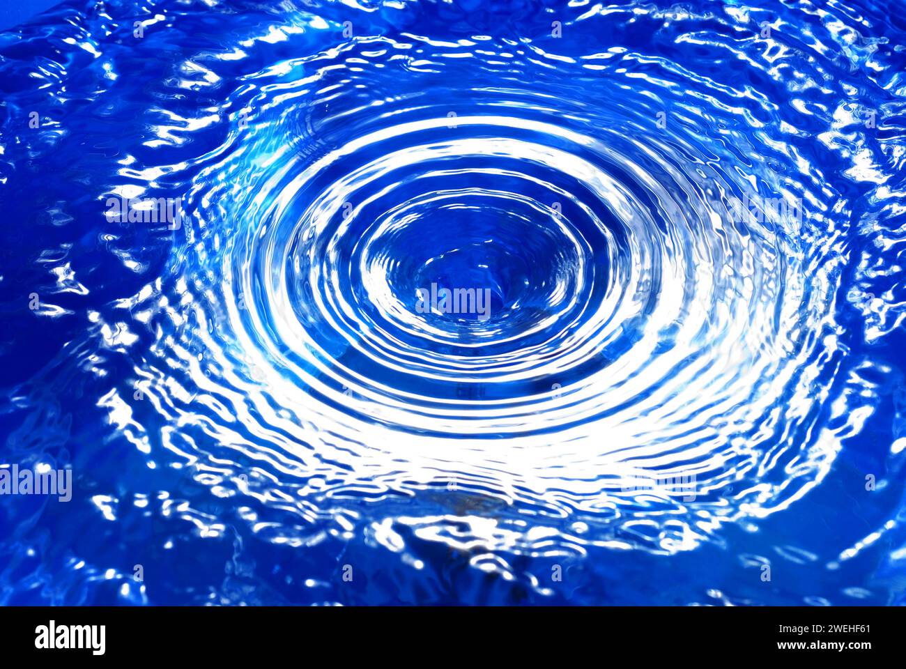 a water vortex in blue water, with concentric circles Stock Photo