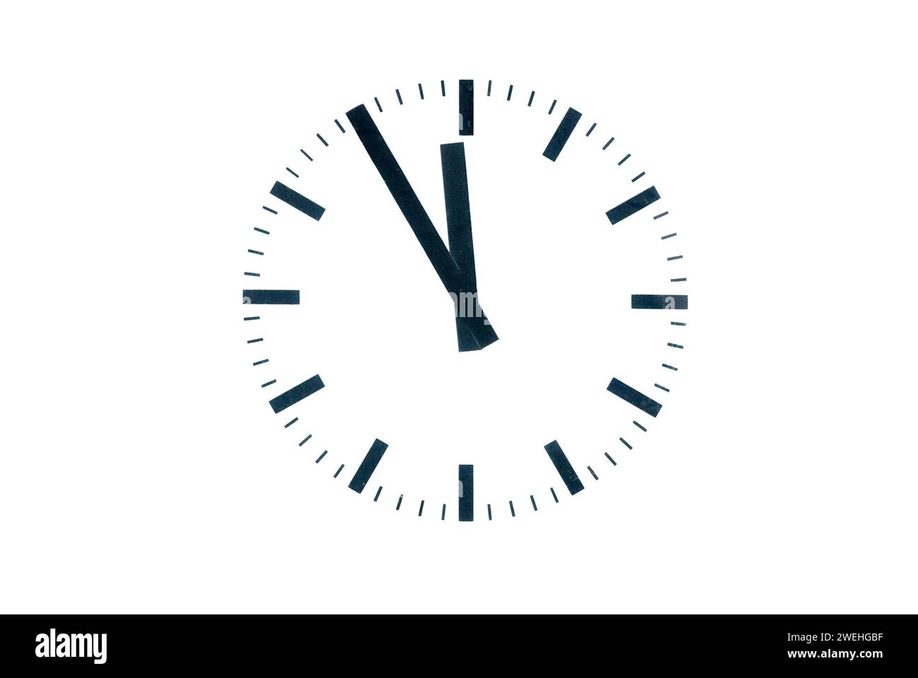 A simple clock shows five to twelve Stock Photo