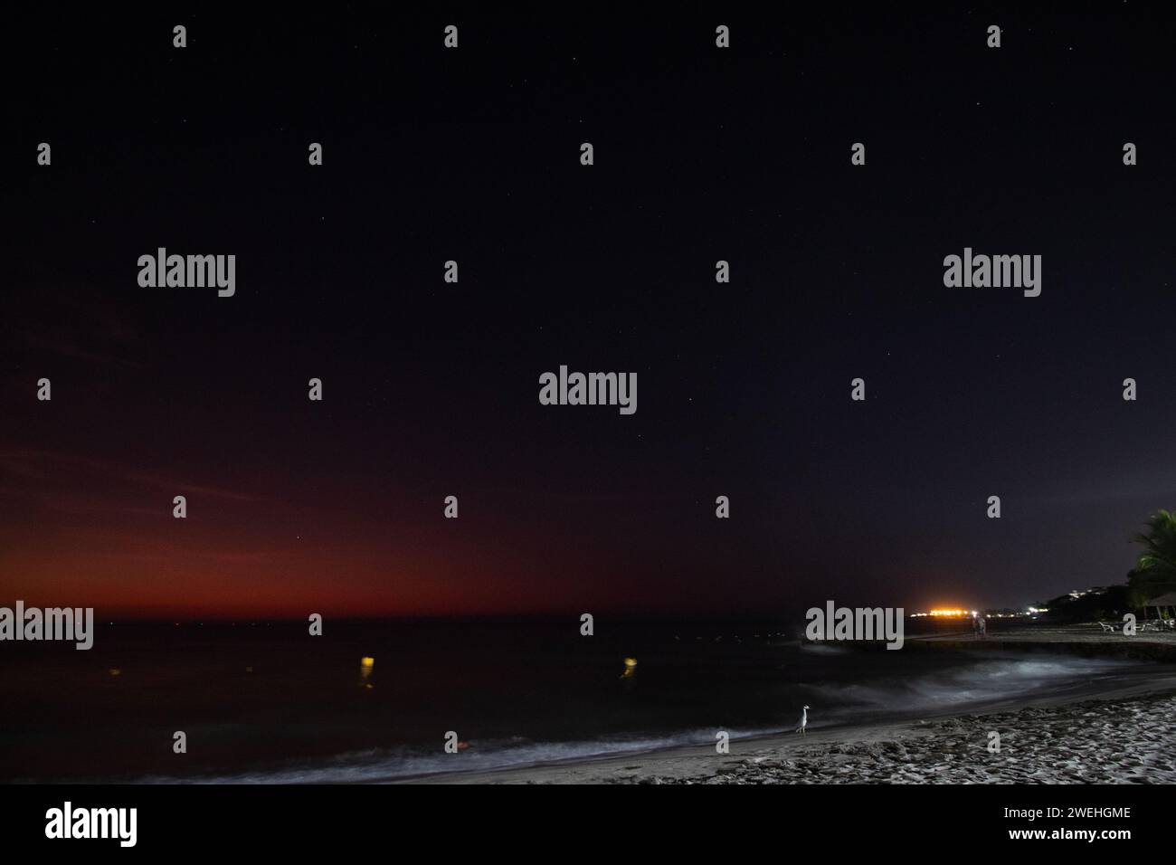 Beautiful starry dusk landscape viewed from a Colombian Santa Marta city beach with Simon Bolivar international airport at background Stock Photo
