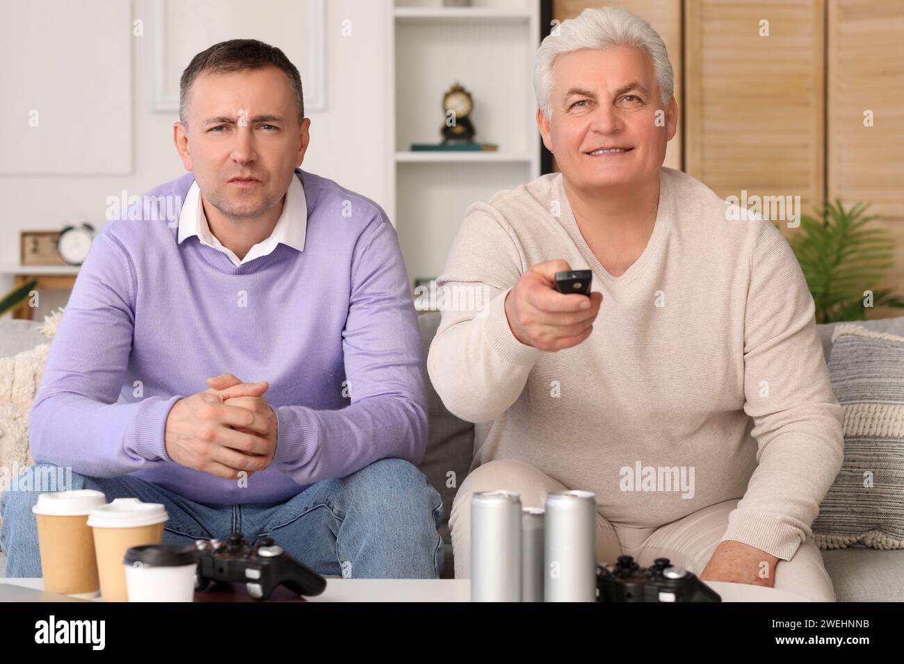 Mature brothers watching TV at home Stock Photo