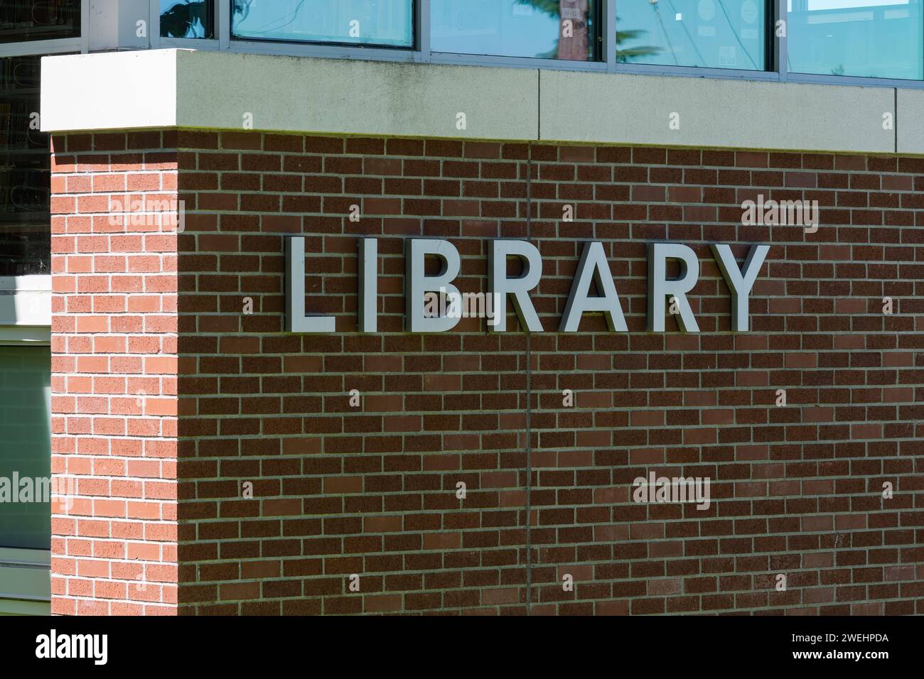 Oregon City, OR, USA - June 11, 2023; Silver metal letters on red brick wall spell word library Stock Photo