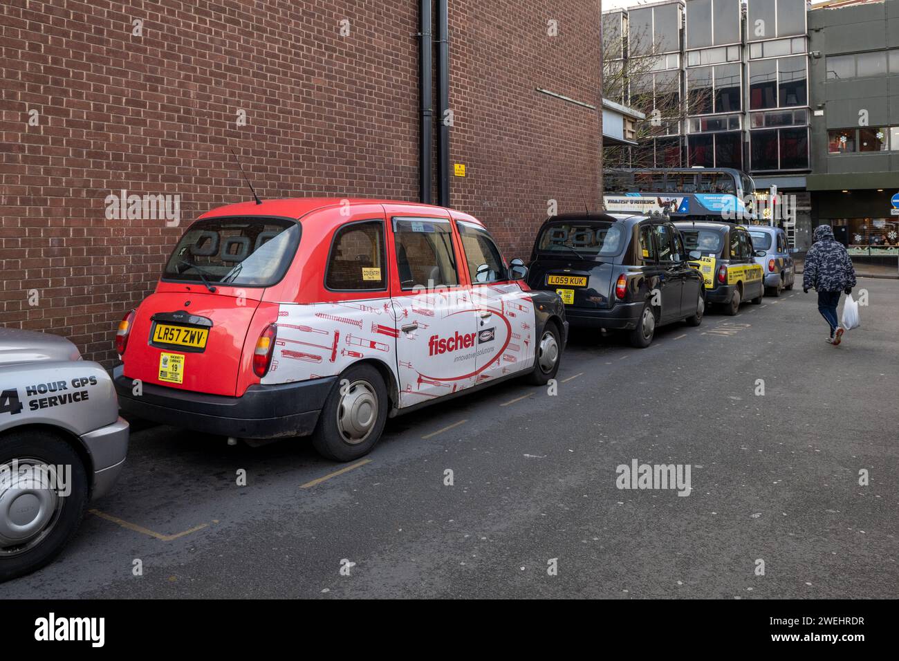 Line of taxis waiting for fares in the Burgess, Coventry, West Midlands, UK. Stock Photo