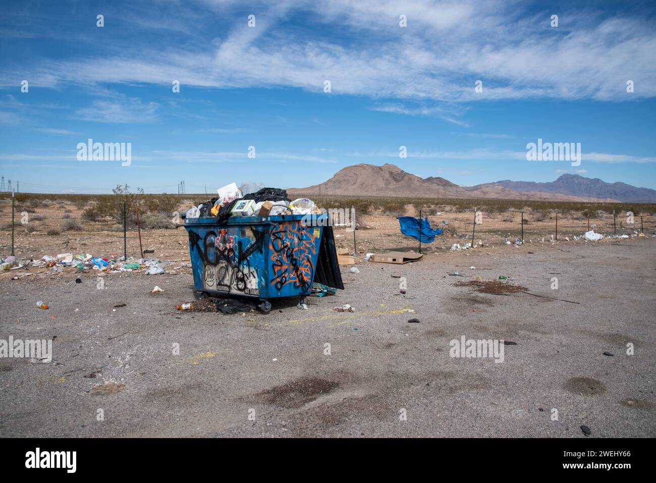 Dumpster overflowing with garbage, trash on the ground, located alongside the I-15 between St. George, Utah, and Las Vegas, Nevada, USA. Stock Photo