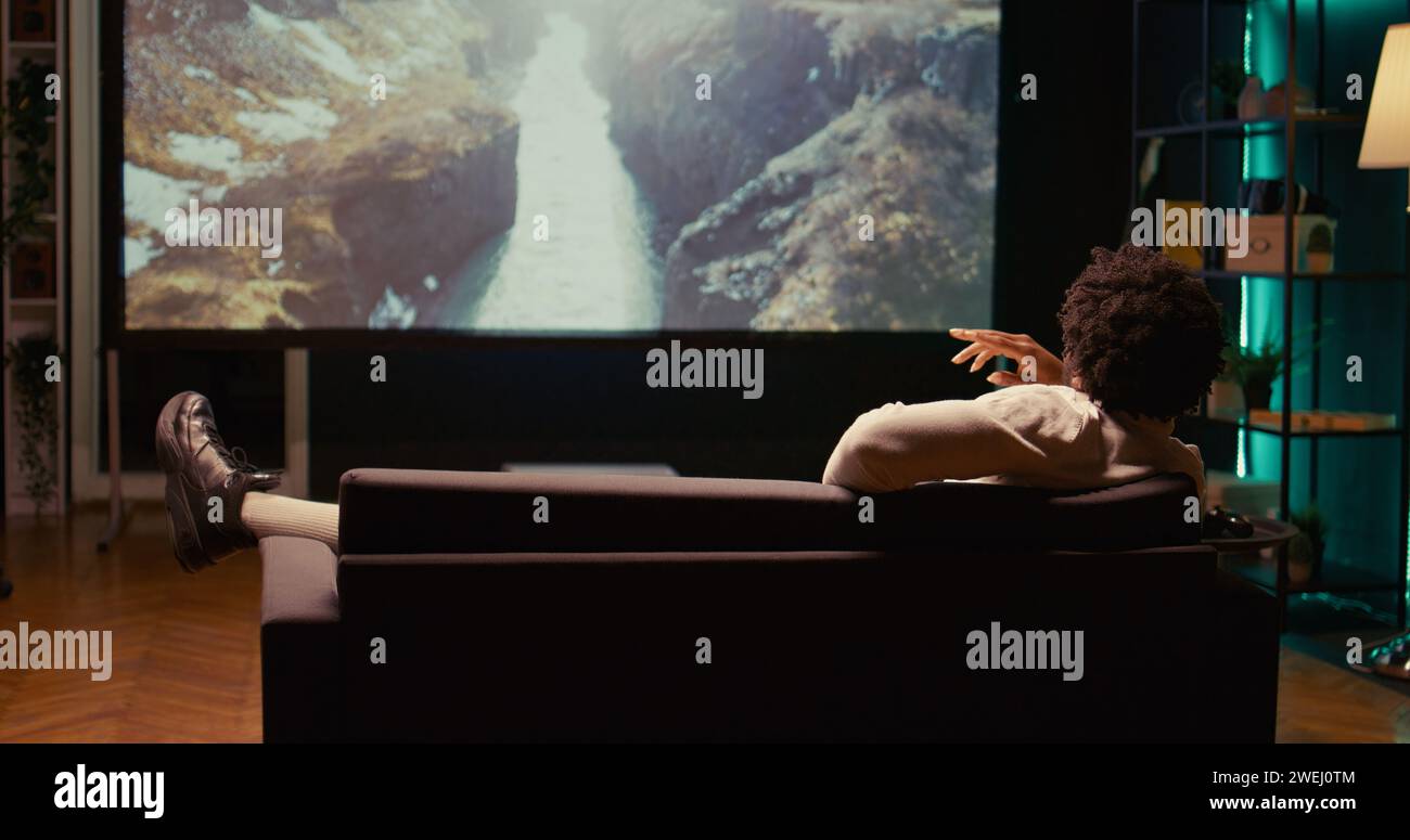 African american man watching nature documentary with beautiful