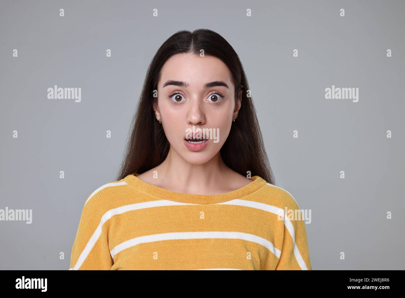 Portrait of surprised woman on grey background Stock Photo - Alamy