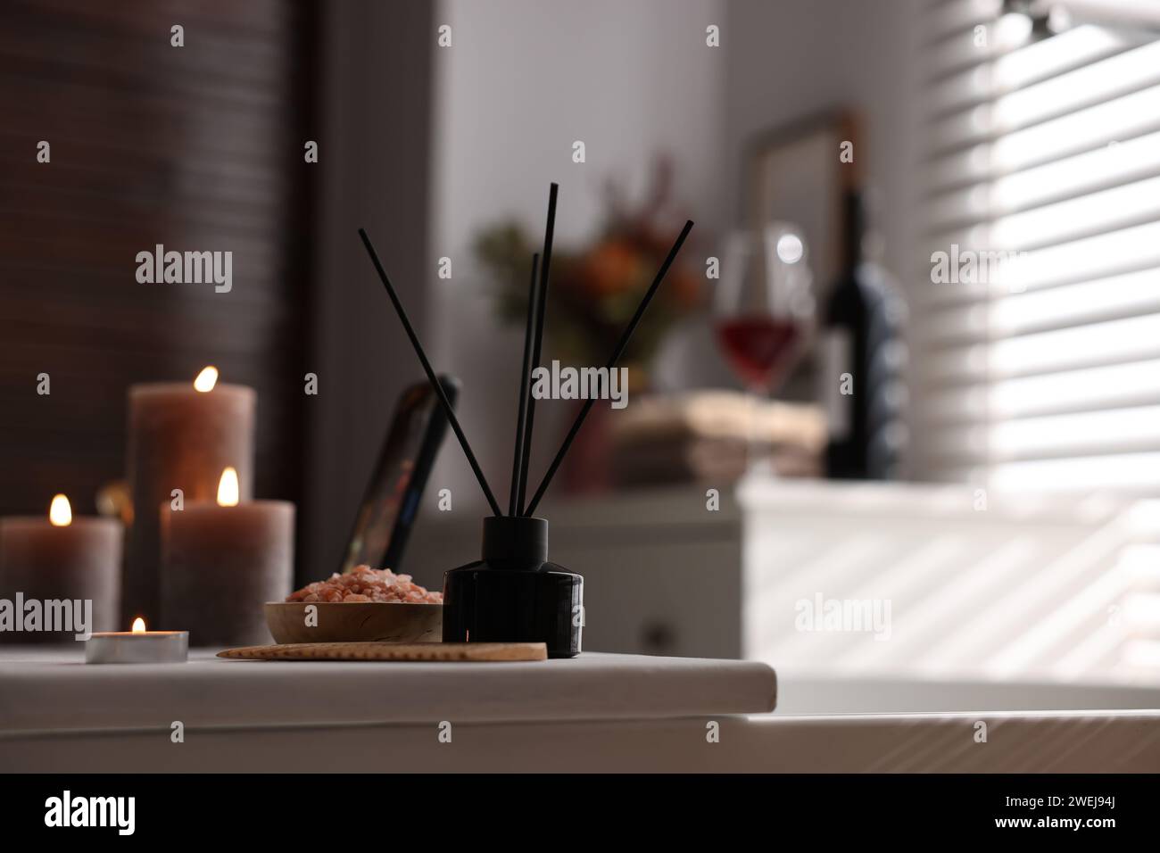 White wooden tray with burning candles, aroma diffuser and sea salt on