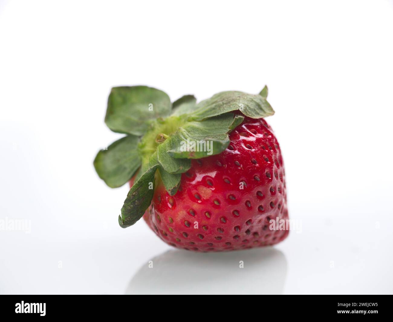 A close up photo of a ripe straberry against a white background. Stock Photo