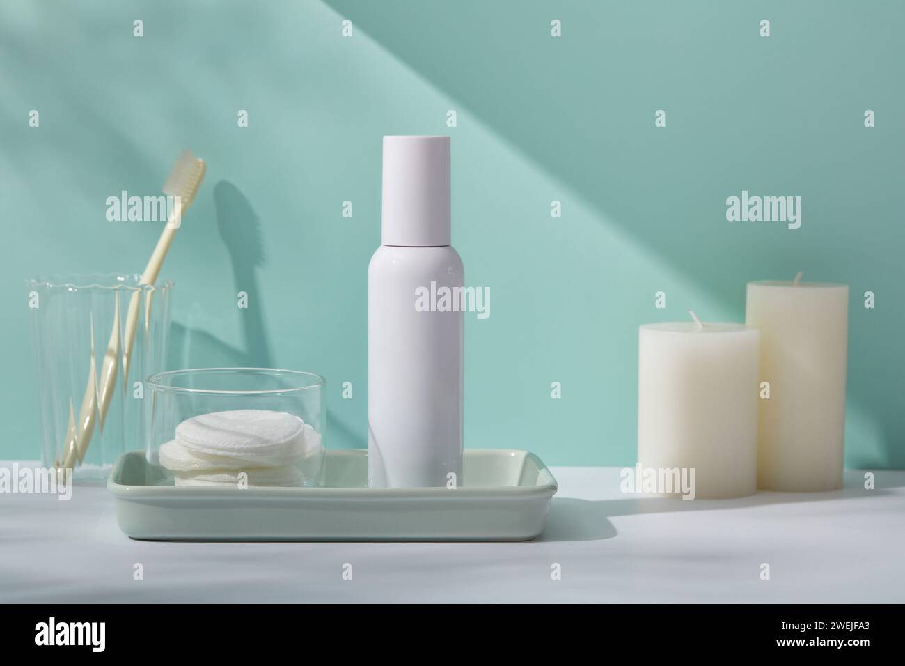 Mockup scene for cosmetic product with plastic bottle without label and remove makeup cotton on rectangle tray, toothbrushes in glass cup and scented Stock Photo