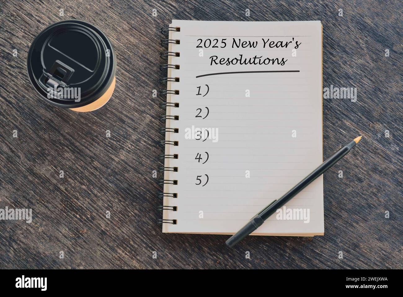 2025 New Year's Resolutions text on notepad on wood desk Stock Photo
