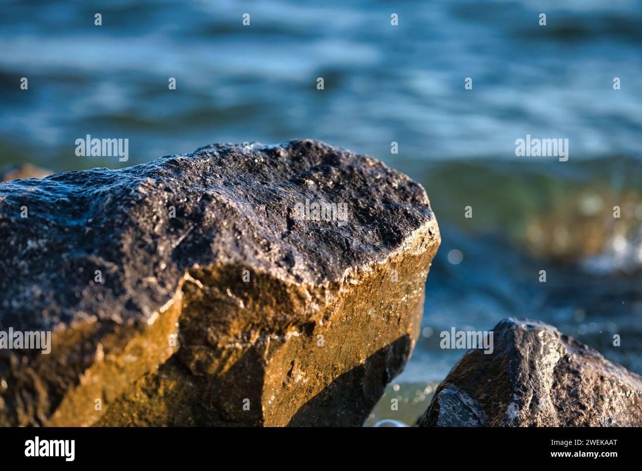 A serene view of two rocks at the water's edge Stock Photo