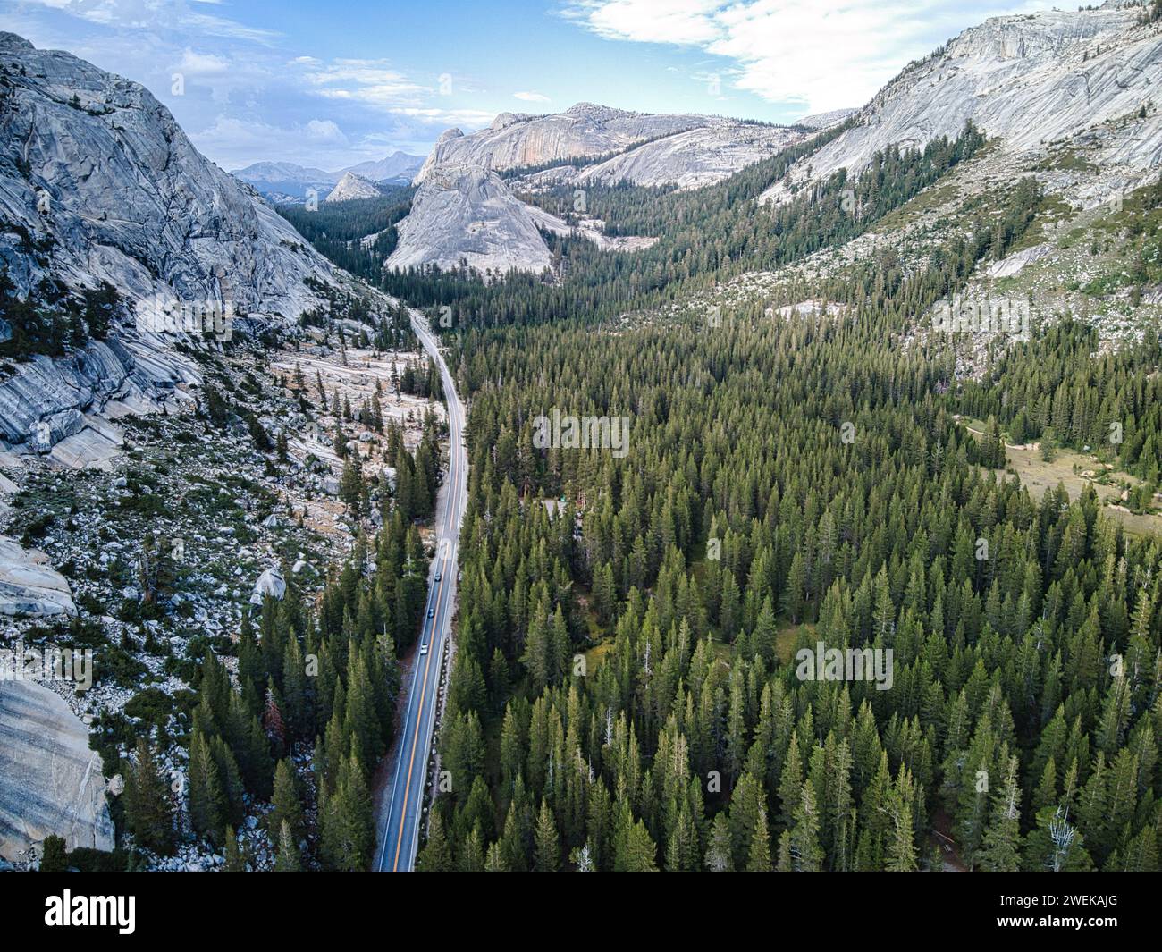 A stunning mountainous landscape featuring a scenic road nestled between two majestic rocky peaks Stock Photo