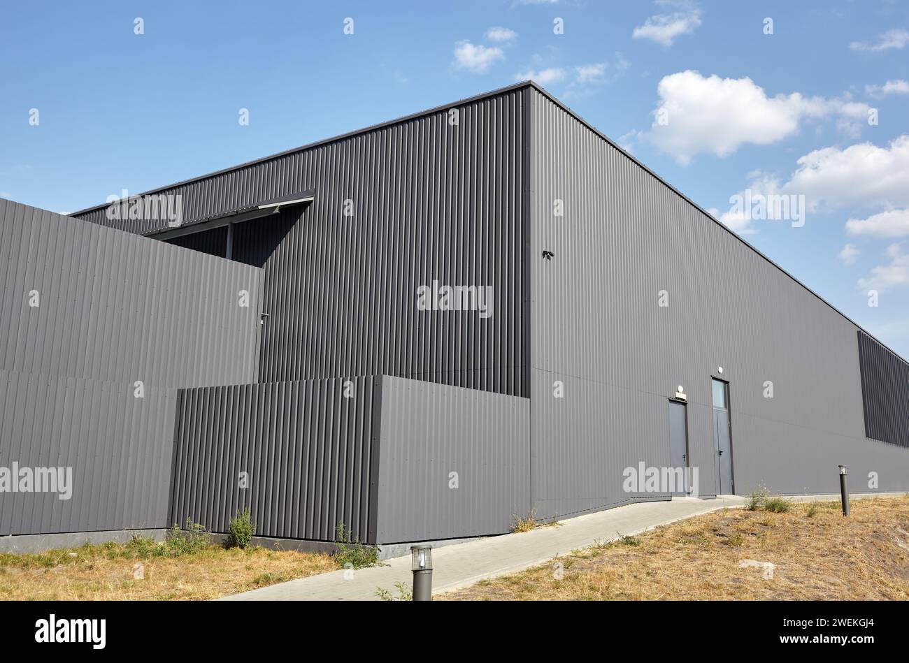 Corrugated steel warehouse or factory industrial building against blue