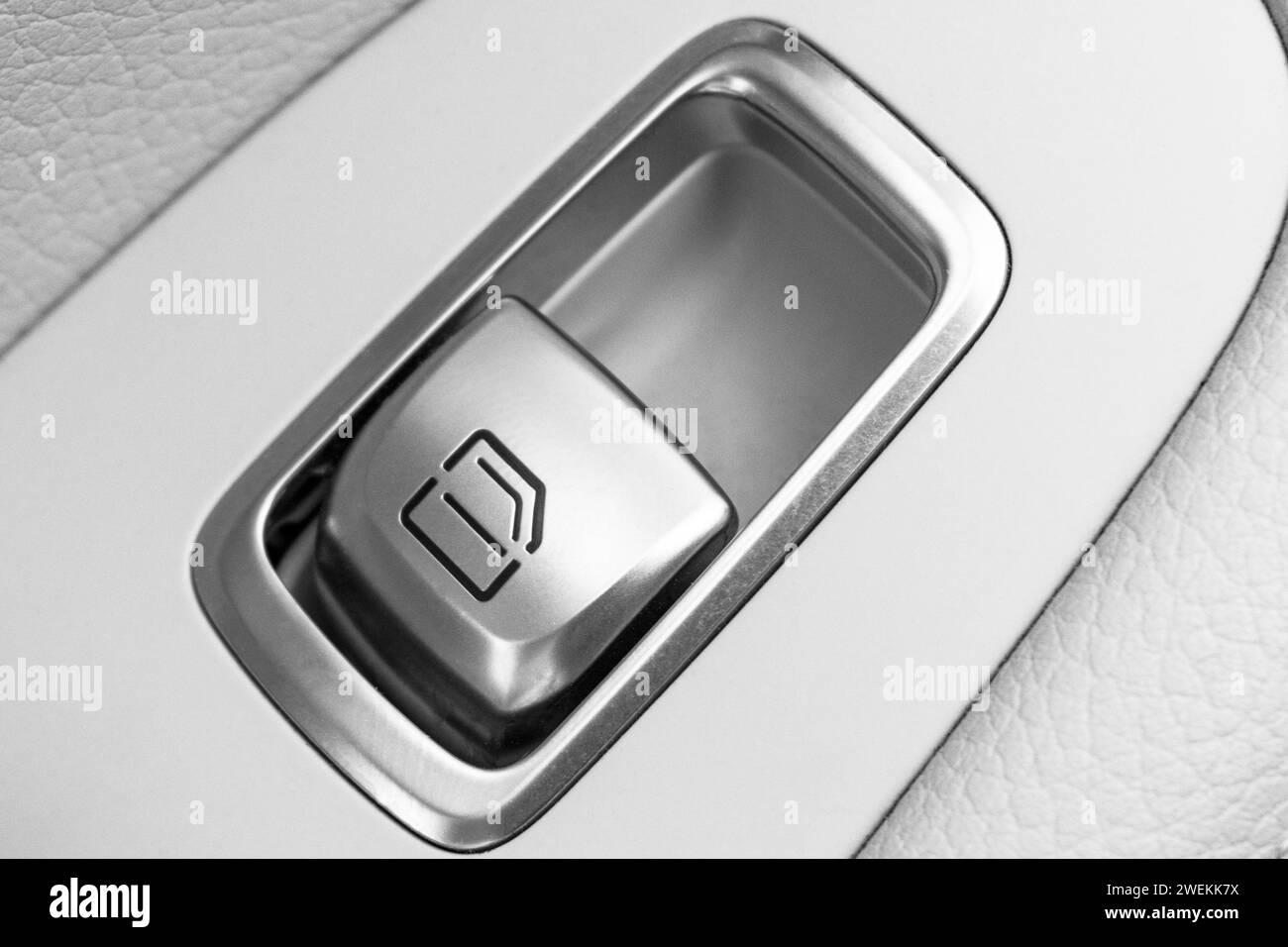 Car white leather interior details of door handle with windows control button. Car window