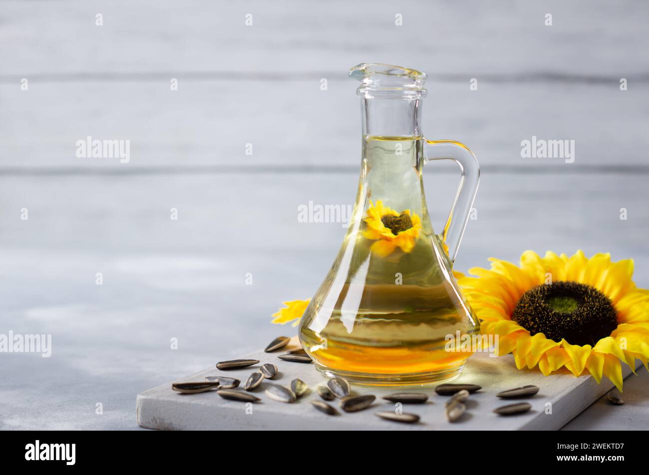 Bottle of sunflower seed oil with flowers on rustic background, cooking ...