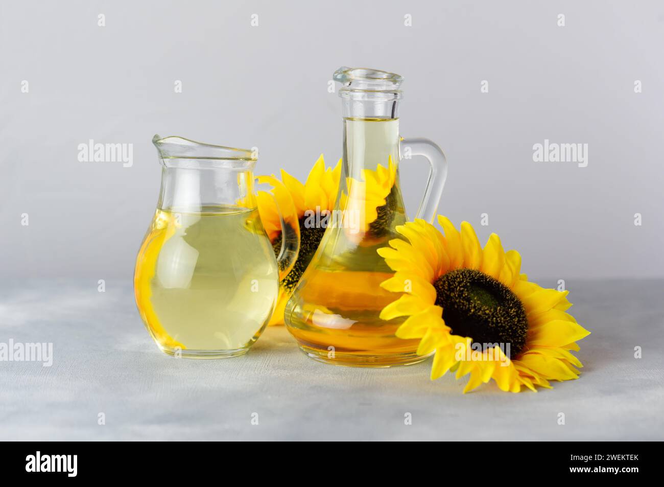 Bottle of sunflower seed oil with flowers on rustic background, cooking ...