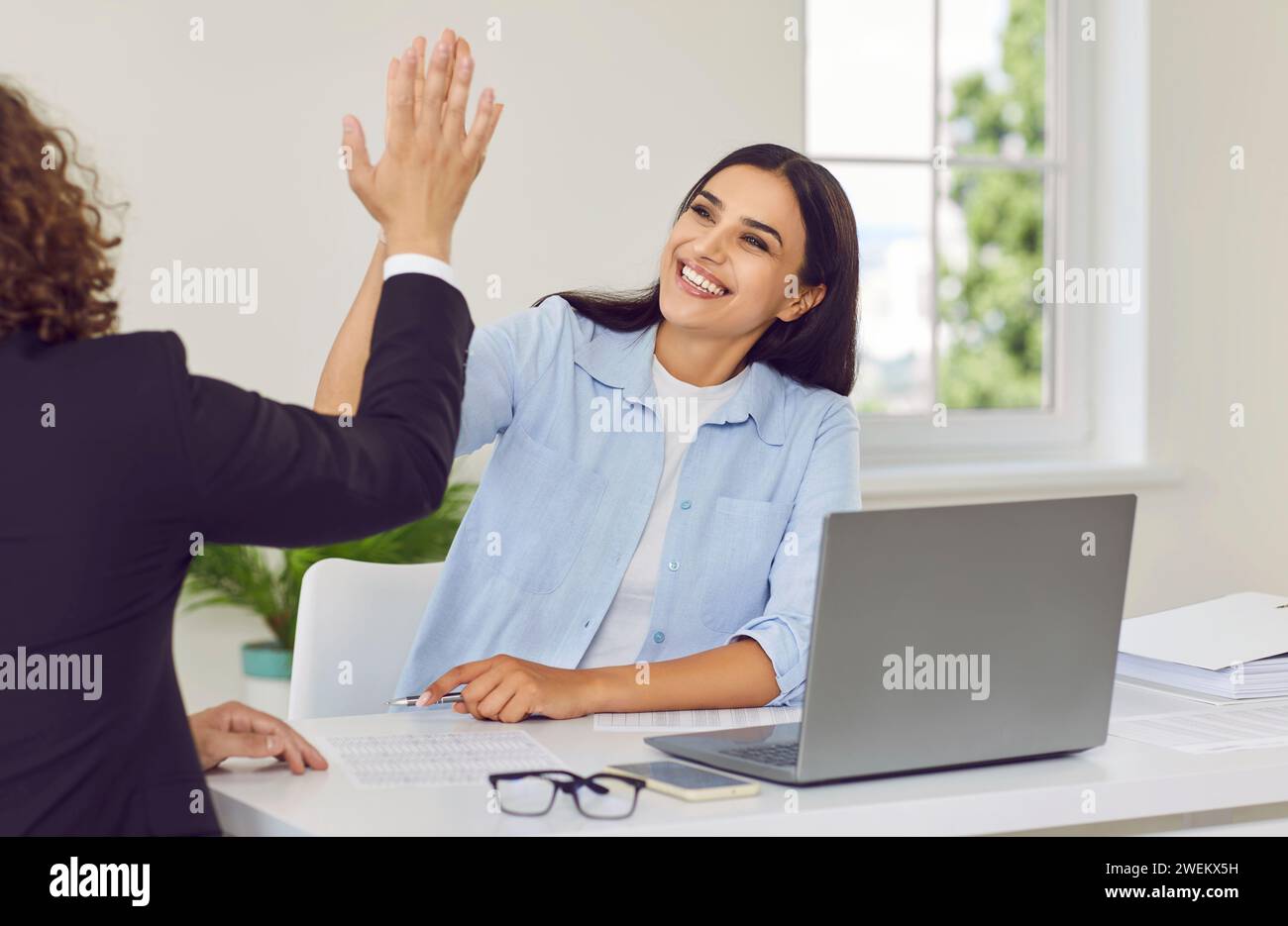 Two happy employees giving high five in office, celebrating success or ...
