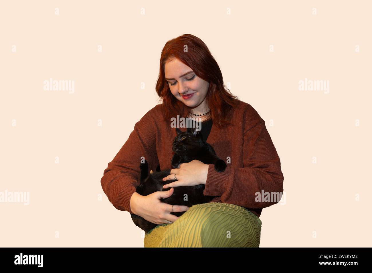 A girl with her black cat and white background Stock Photo