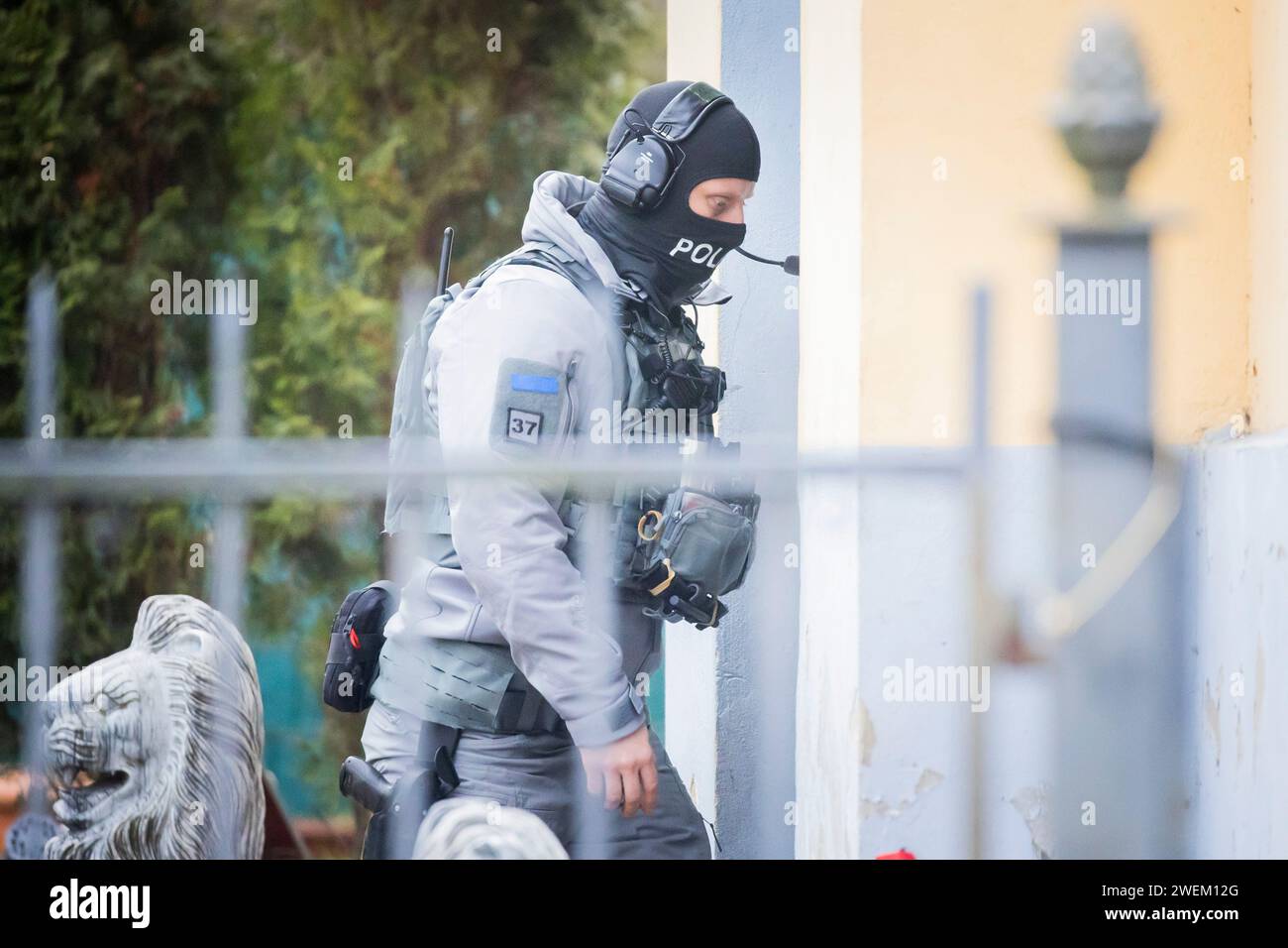 Berlin, Germany. 26th Jan, 2024. A police officer is on duty outside a villa belonging to a clan in the Berlin district of Buckow in the Neukölln borough. Due to the attack on a policewoman by a clan member on New Year's Eve, there was another police operation at the villa of the extended family. According to the police, there is no connection with the planned eviction of the villa by the Neukölln district. Credit: Christoph Soeder/dpa/Alamy Live News Stock Photo