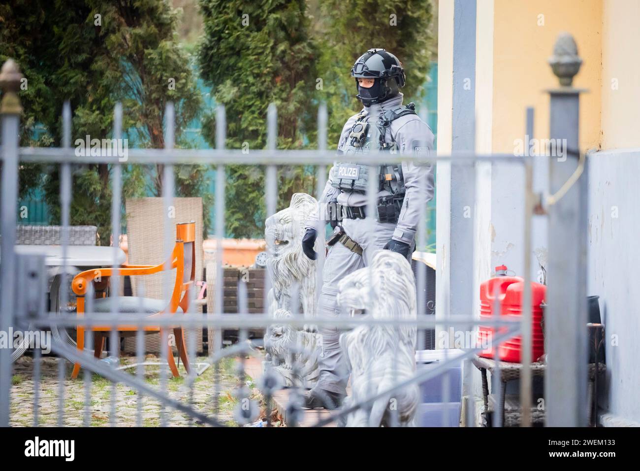 Berlin, Germany. 26th Jan, 2024. A police officer is on duty outside a villa belonging to a clan in the Berlin district of Buckow in the Neukölln borough. Due to the attack on a policewoman by a clan member on New Year's Eve, there was another police operation at the villa of the extended family. According to the police, there is no connection with the planned eviction of the villa by the Neukölln district. Credit: Christoph Soeder/dpa/Alamy Live News Stock Photo