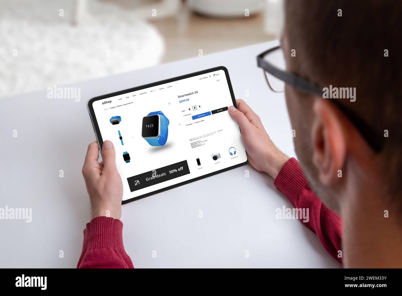 Guy shops for a smartwatch online on a modern e-commerce webpage.  Technology browsing for the latest in wearable gadgets Stock Photo