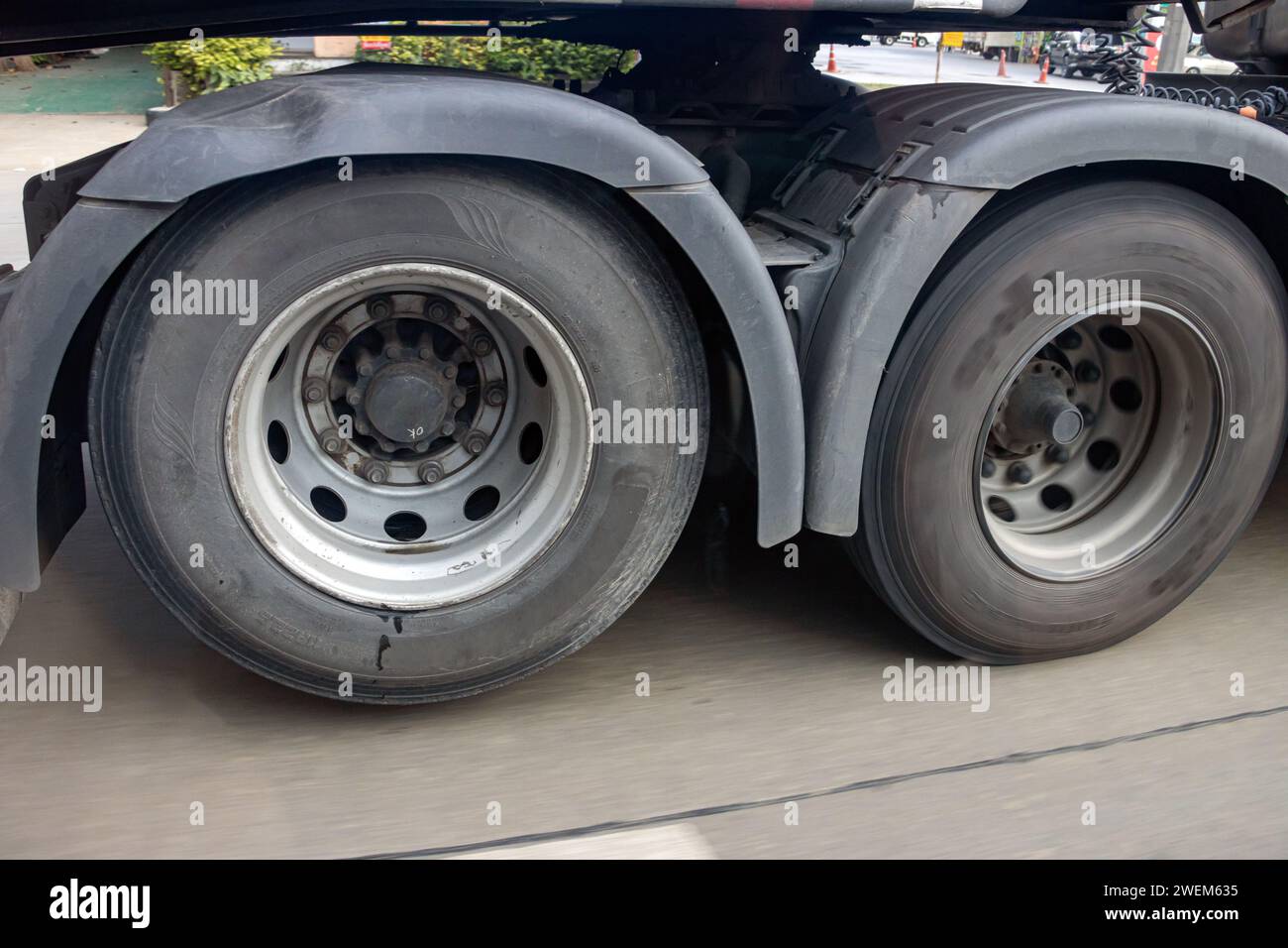 View of the rear wheels of a truck while driving with the rear axle raised Stock Photo