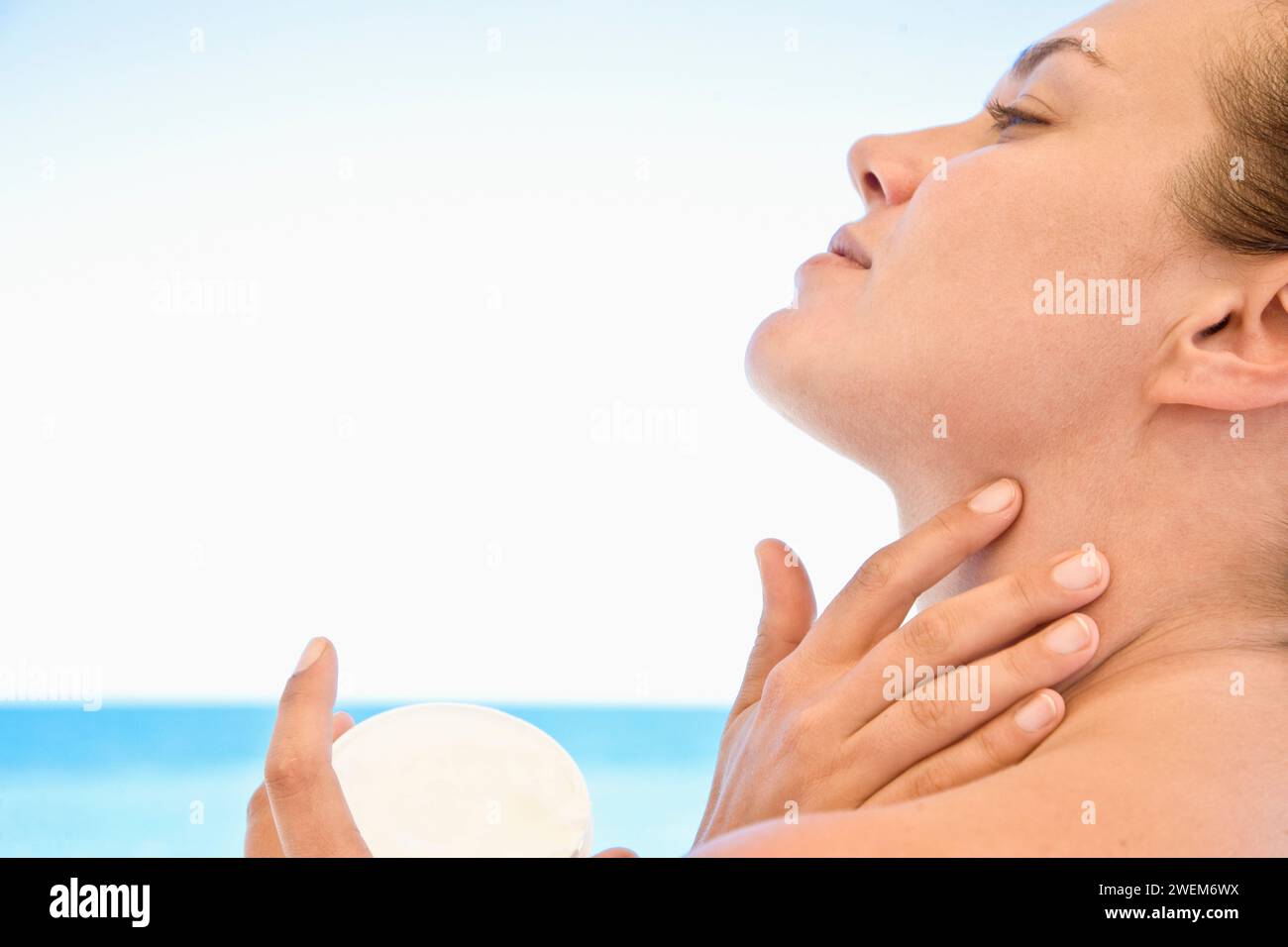 Applying sunscreen cropped woman young hires stock photography and