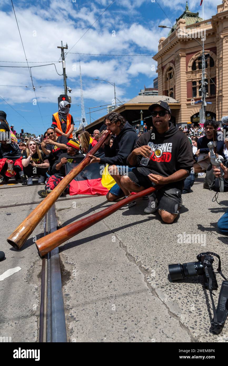 Melbourne, Australia. 26th Jan, 2024. Men play didgeridoos outside