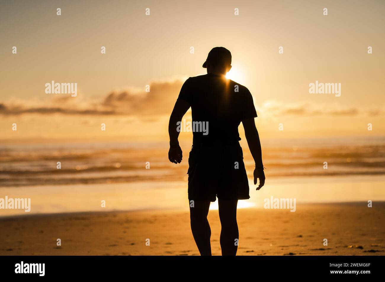 Beach Sunset and Contemplative Man Walking Stock Photo - Alamy