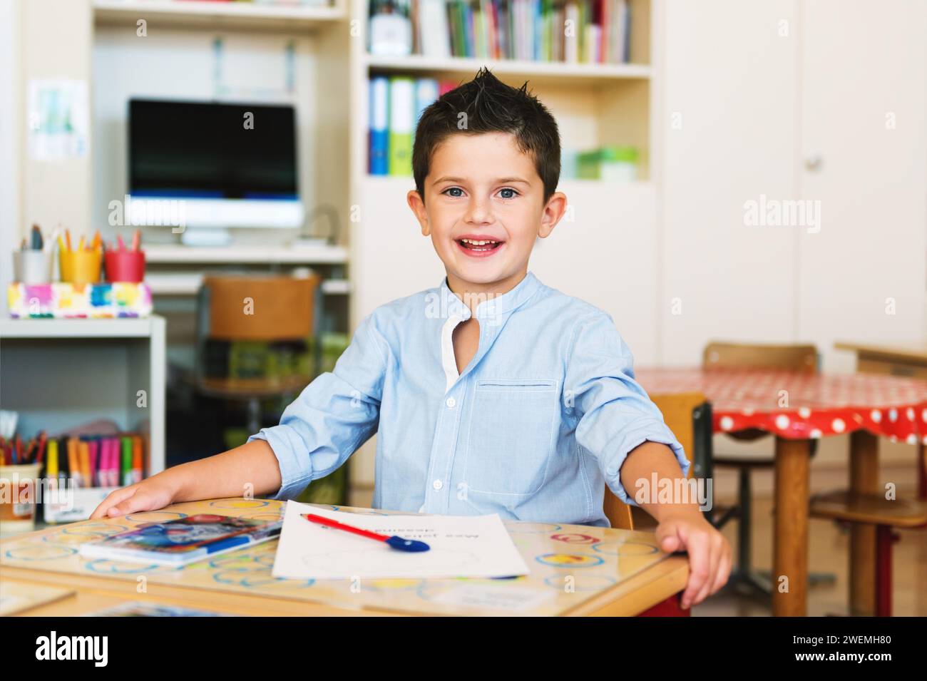 Indoor portrait of a cute little boy in a classroom Stock Photo - Alamy