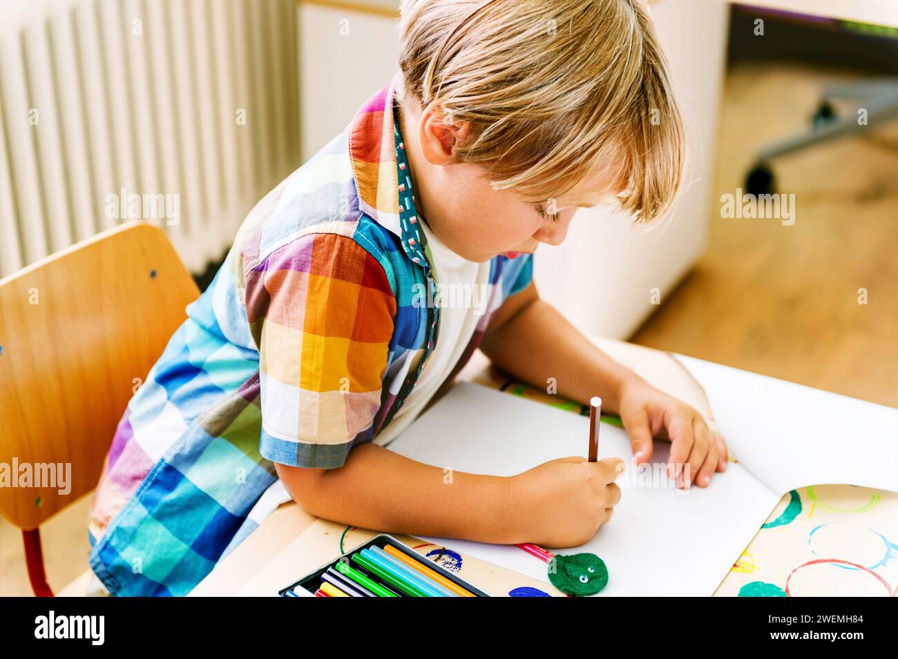 Indoor portrait of a cute little boy in a classroom Stock Photo - Alamy
