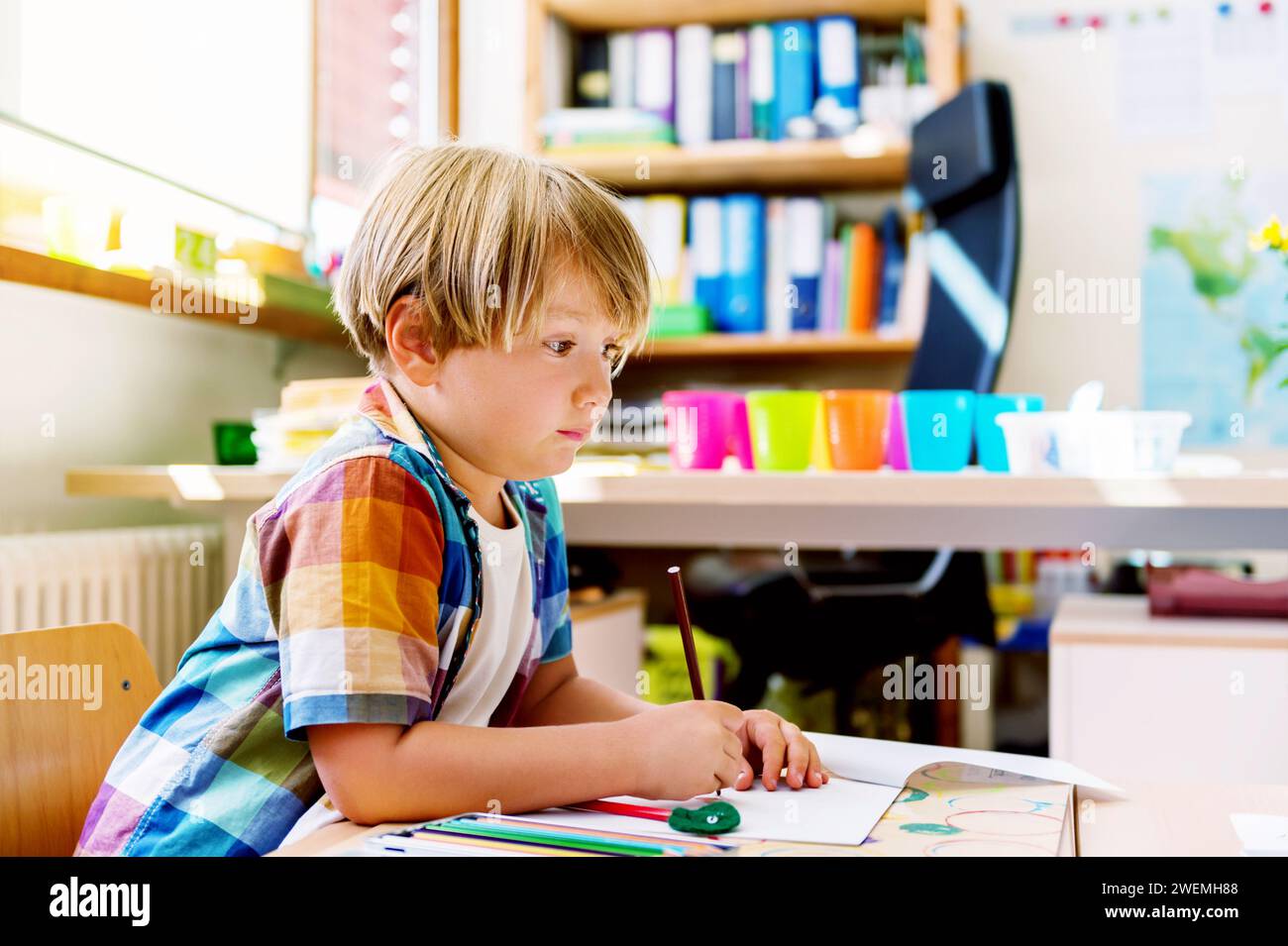 Indoor portrait of a cute little boy in a classroom Stock Photo - Alamy