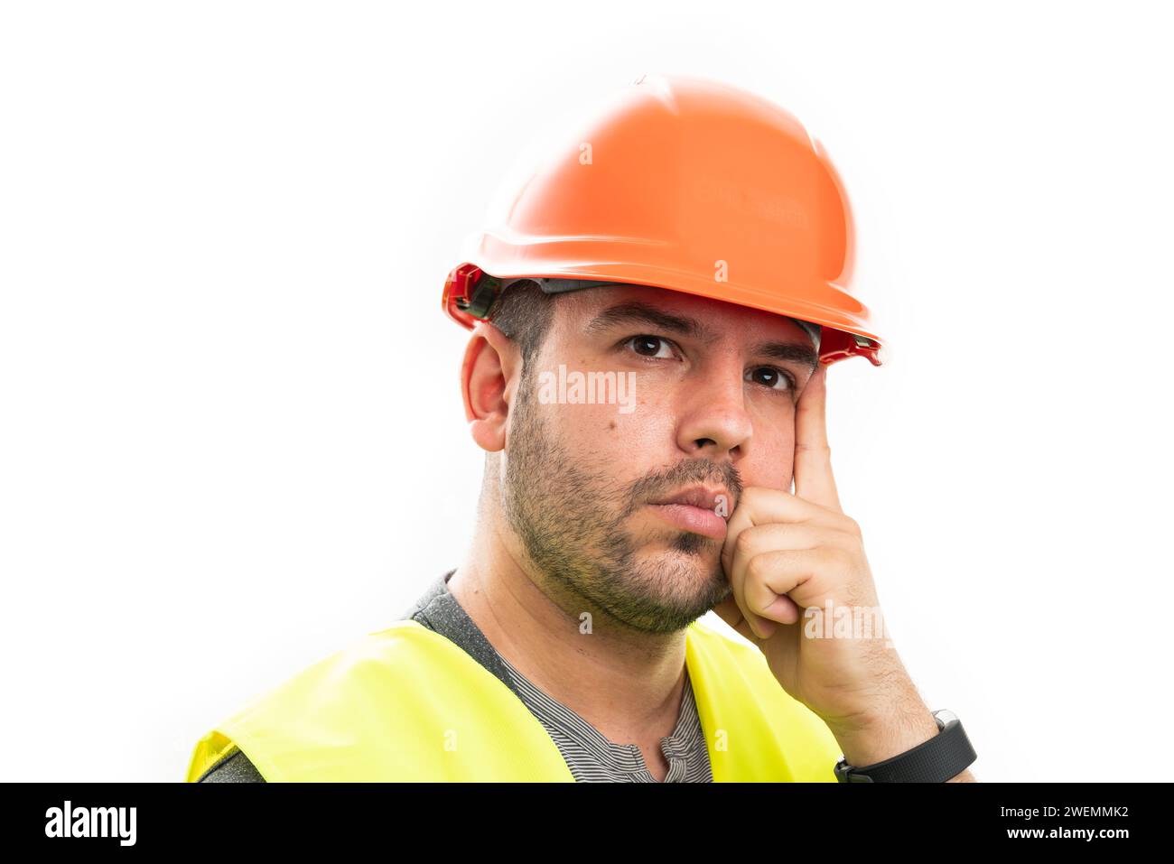 Close-up of serious adult male builder making thinking considering gesture with index finger touching temple wearing vest and orange safety helmet iso Stock Photo