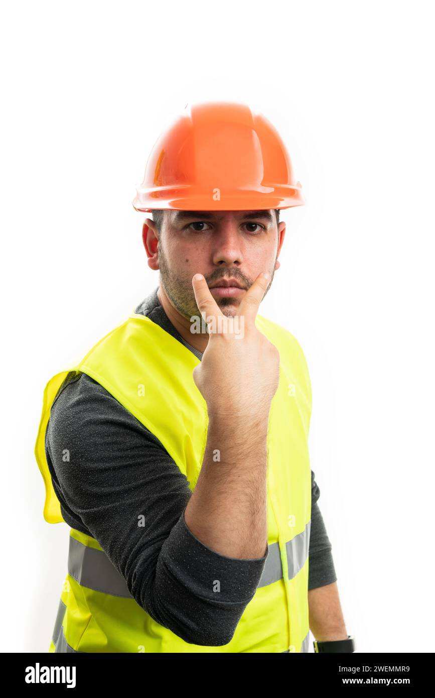 Model as constructor man wearing orange safety helmet and fluorescent clothing making eye-contact gesture pointing fingers as supervisor concept isola Stock Photo