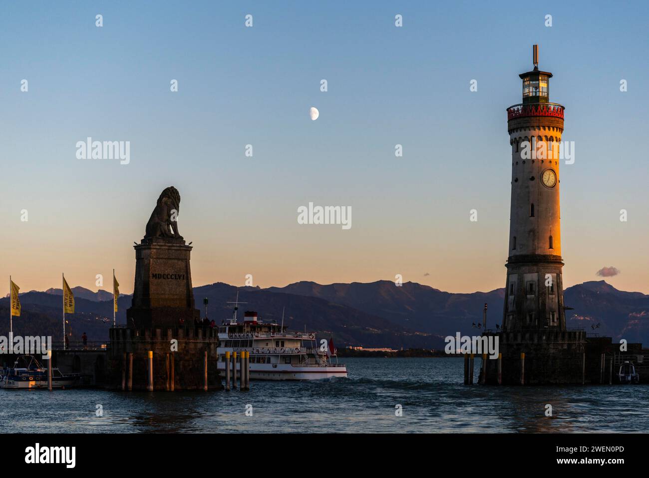 Lindau at Lake Constance, entrance to the harbour, Bavarian lion, new lighthouse, view of the Alps, passenger ship, half moon, evening light Stock Photo