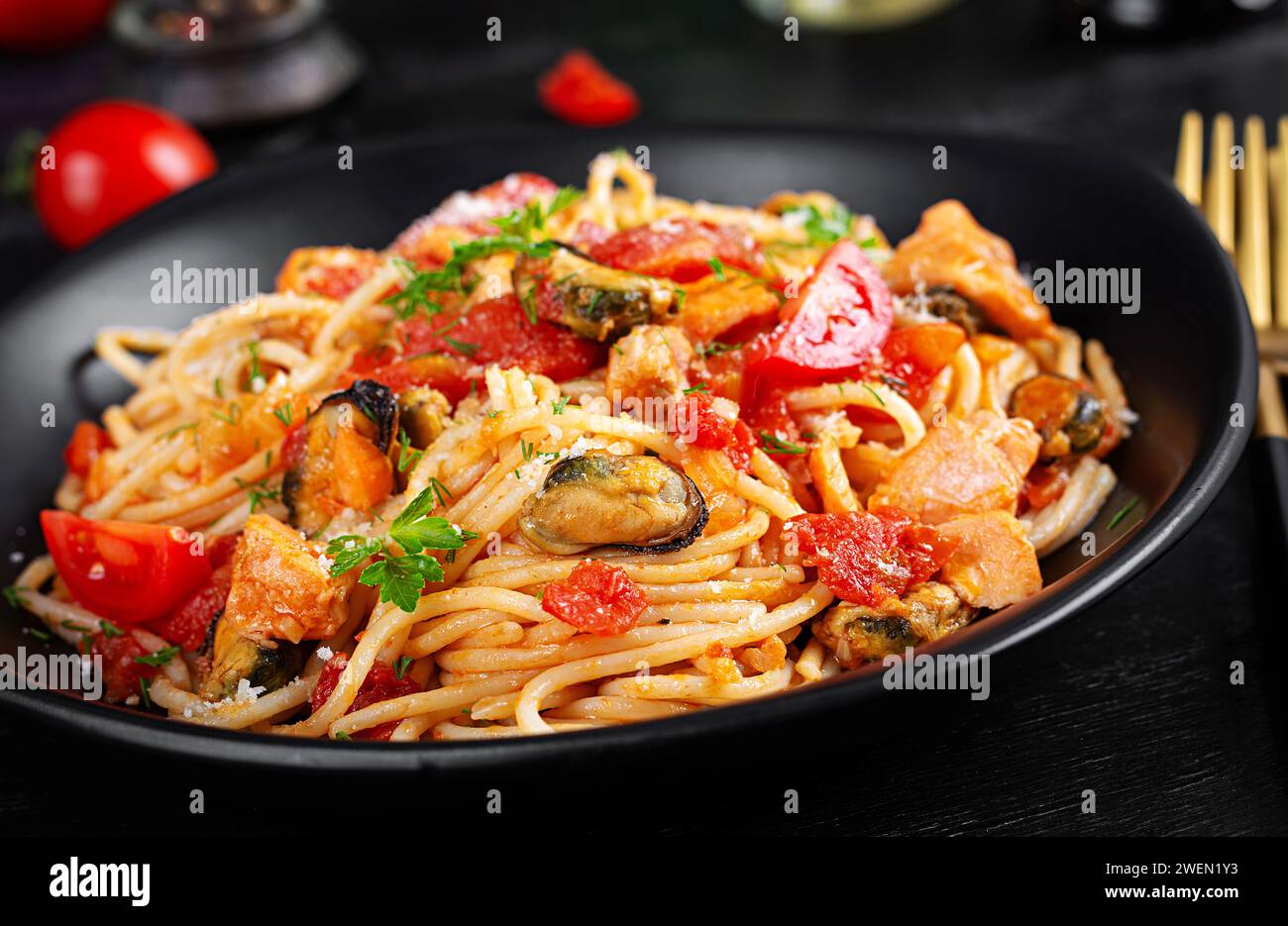 Classic italian pasta spaghetti marinara with mussels and salmon on dark table. Spaghetti pasta with sauce marinara. Stock Photo