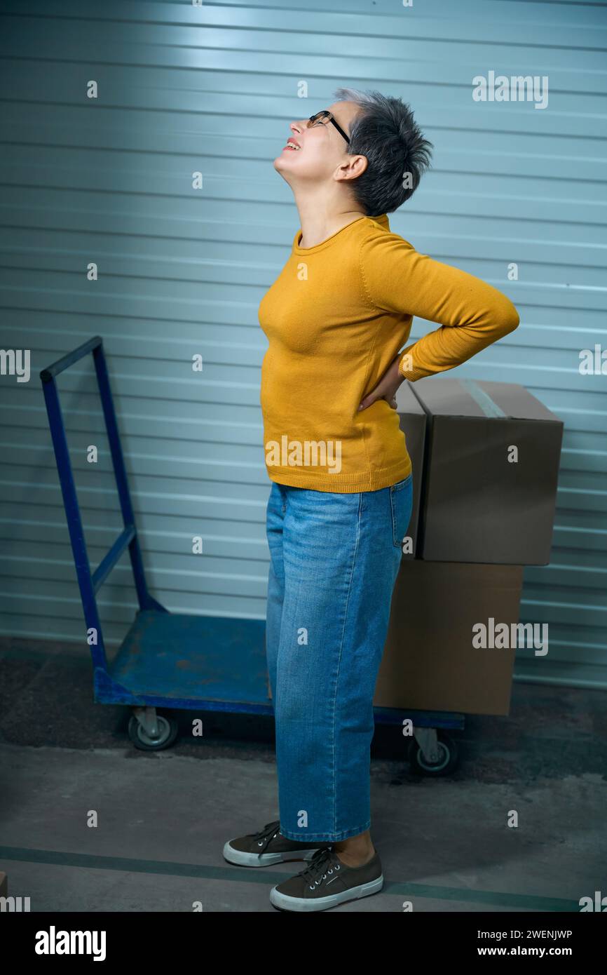 Back hurts after transporting things in cardboard boxes Stock Photo