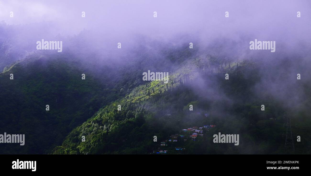 cloudy and misty lush green himalaya mountain foothills and countryside panoramic view near darjeeling hill station in monsoon season, india Stock Photo