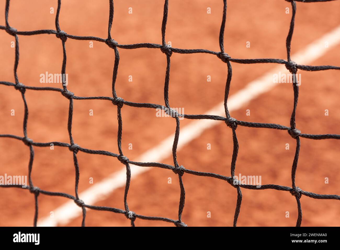 Tennis net. Close-up view of the nodes of a sports net against the background of a court with a ground surface Stock Photo